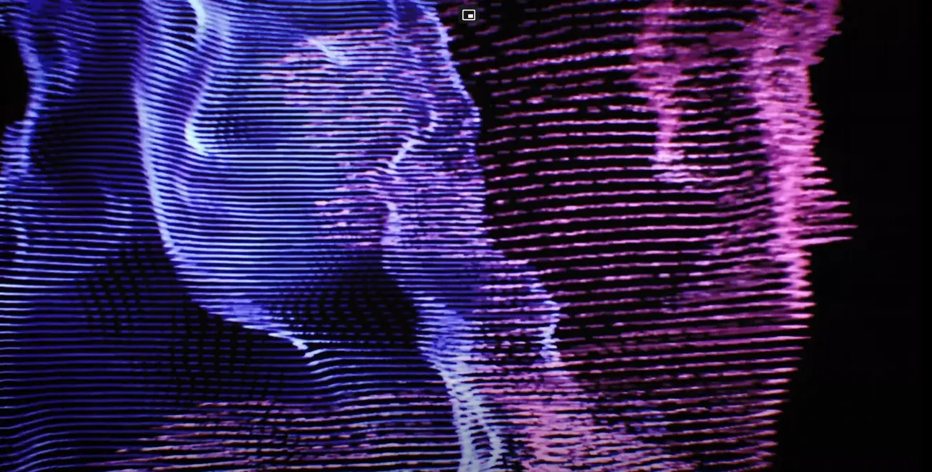 Pretty Blonde Boy music video frame showing a point-cloud body dissolving into scattered particles